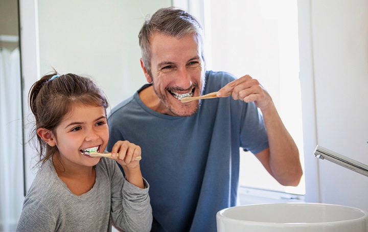 Humans of various sizes brushing their teeth