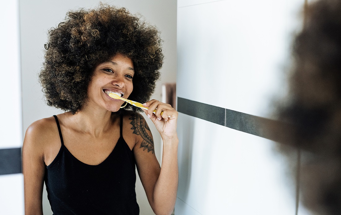 Individual with fantastic hair brushing teeth