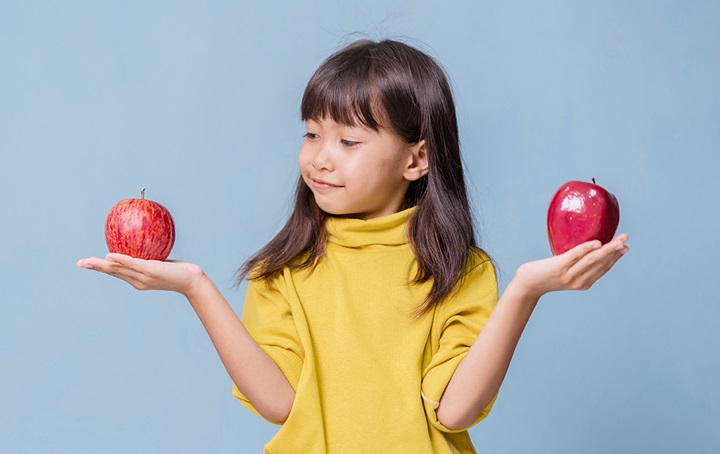 Child holding two apples